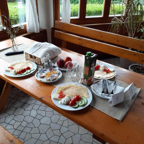 a wooden table with plates of food on it at Penzion Terasa, bed & breakfast in Velké Losiny