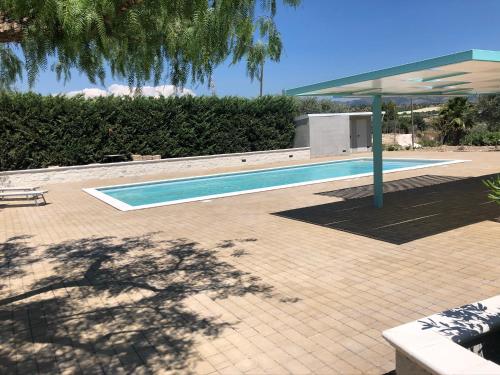 una piscina di fronte a una casa di Terre Iblee Resort a Chiaramonte Gulfi