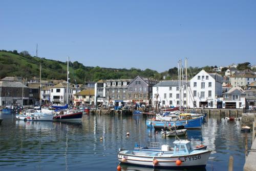 un grupo de barcos están atracados en un puerto en Harbourside Apartment, en Mevagissey