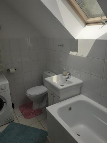 Baño blanco con lavabo y aseo en Apartament 107 B, Noclegi pod dobrym Aniolem, en Kudowa-Zdrój