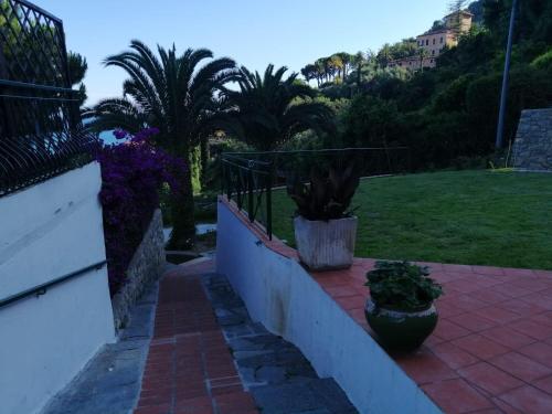 a balcony with two potted plants on a brick sidewalk at Agriturismo Un Mare di Fiori in Ventimiglia