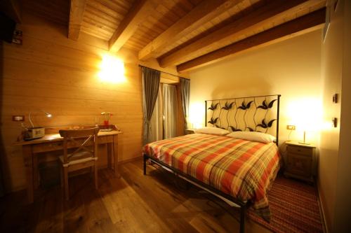 a bedroom with a bed and a table and a desk at Le Case dei Baff in Morbegno