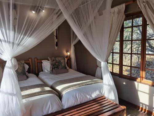 Giường trong phòng chung tại Thornhill Safari Lodge