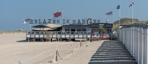 a restaurant on the beach next to a sandy beach at De Loft in Zuid-Scharwoude