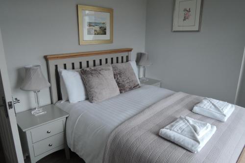 a bedroom with a white bed with two pillows at Tigh Beg Croft in Lerags