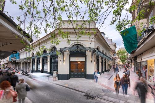 a group of people walking on a street in front of a building at Athens Manor Houses in Athens