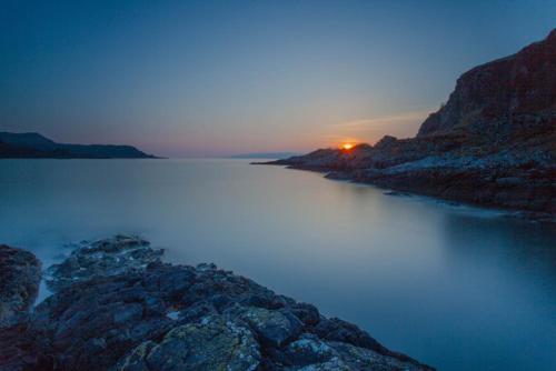a large body of water with a sunset in the background at Tigh Beg Croft in Lerags