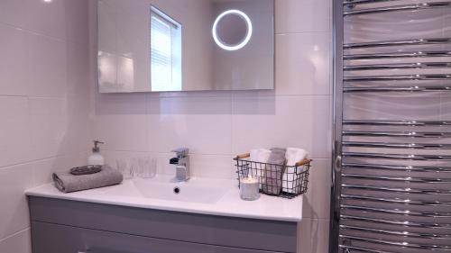 a white bathroom with a sink and a mirror at River Mist in Ironbridge
