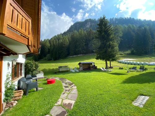 a backyard with a grassy yard with a table and chairs at Chalet Romy Ap2 in Pramauron