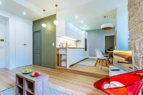 Il comprend un salon avec une chaise rouge et une cuisine. dans l'établissement Maison Bianchi - Biscarra, à Nice