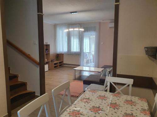 a kitchen and dining room with a table and chairs at Flower Apartment in Hévíz