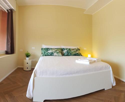 Un dormitorio con una gran cama blanca con una vela. en CIGNI HOUSE - da Anna&Ale, en Basiglio