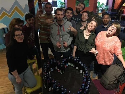 a group of people standing in front of a table with a cake at Auberge Alternative in Montréal