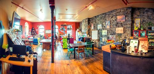 Habitación con biblioteca con mesas y sillas en Auberge Alternative, en Montreal