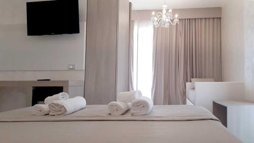a bedroom with towels on a bed with a fireplace at Hotel Aurora in Porto Cesareo