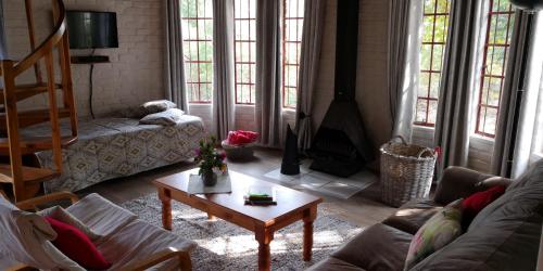 a living room with a couch and a coffee table at Athanor Cottages in Hogsback