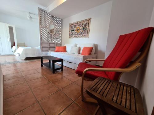 a living room with a couch and a red chair at Las Negras CENTRO. Al lado del mar. Con dos terrazas in Las Negras