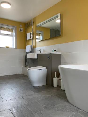 uma casa de banho com uma banheira, um WC e um lavatório. em The Red Lion Inn em Spilsby