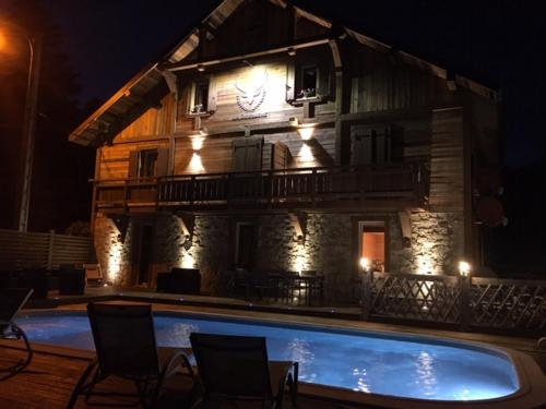 a building with a swimming pool in front of it at Maison La Devinière - sauna et spa compris accessibles toute l'année in Xonrupt-Longemer