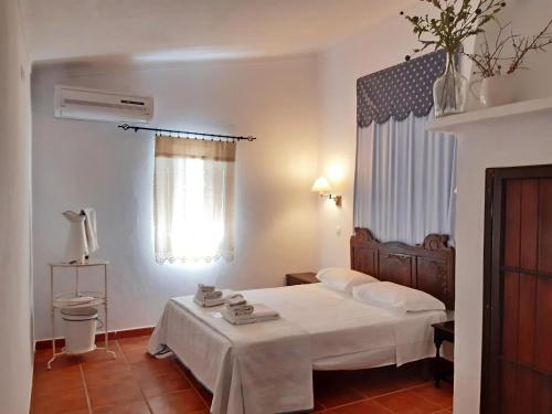 a hotel room with a bed and a window at Horta do Muro in Campo Maior