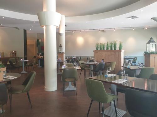 a restaurant with tables and chairs in a room at Fletcher Strandhotel Renesse in Renesse