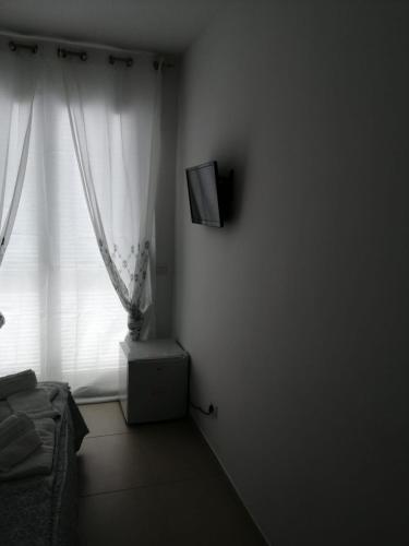 a room with a tv on a wall with a window at Hotel Tirreno Formia in Formia