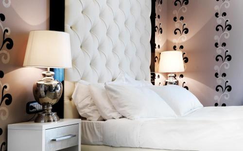 a bedroom with a white bed with two lamps at LE RÊVE DE NAIM Roma in Rome
