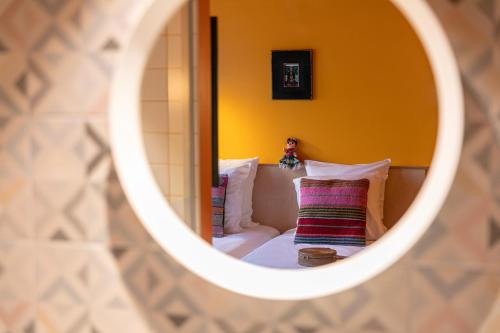 a mirror reflecting a bedroom with a bed and pillows at PAUL & PIA - Welcome Home Hotel in Colmar