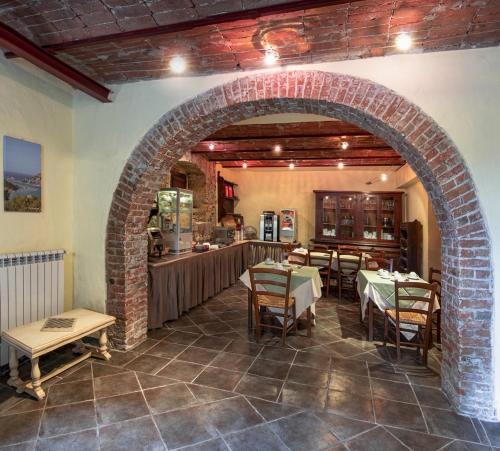 サルザーナにあるAlbergo La Villettaのテーブルと椅子のあるレストランのアーチ道
