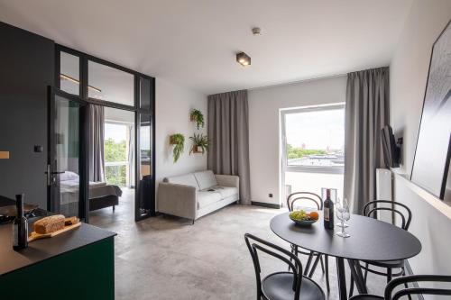 a living room with a table and chairs and a couch at TOP Garden Aparthotel in Toruń