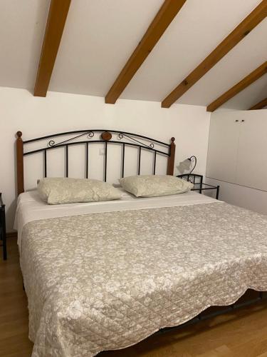 a bedroom with a large bed with a wooden headboard at Apartments Miljas in Cavtat