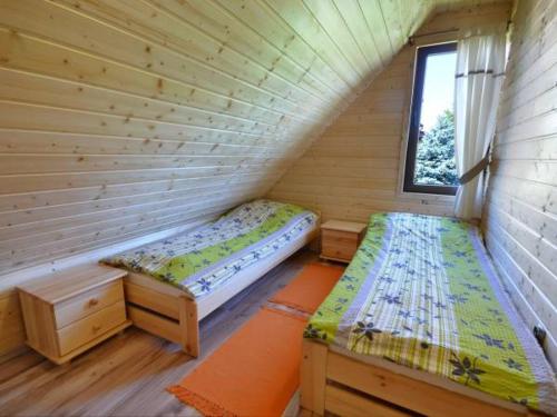 Ένα ή περισσότερα κρεβάτια σε δωμάτιο στο Domki drewniane u Marioli