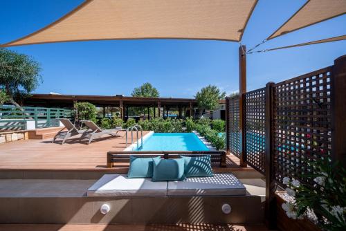 a patio with a swimming pool and an umbrella at Dolce by Wyndham Athens Attica Riviera in Vravrona