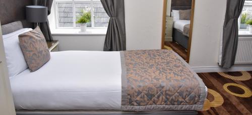 a bedroom with a white bed with a blanket at Kildare House Hotel in Kildare