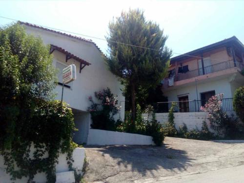 a white house with a tree in front of it at ilias appartements tsaprounis in Elliniká