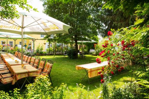 a group of tables and an umbrella in a garden at Hotel zur Post in Mülheim an der Mosel