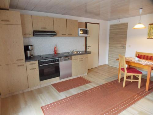 a kitchen with a table and a stove top oven at Ferienwohnung Dimpfl-Stad´l Fam. Lemberger in Lohberg