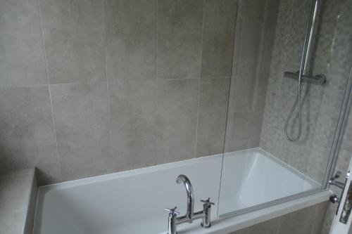 a bathroom with a shower and a bath tub at Tigh Beg Croft in Lerags