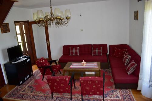 a living room with a red couch and red chairs at Holiday Home Amzici in Amzići