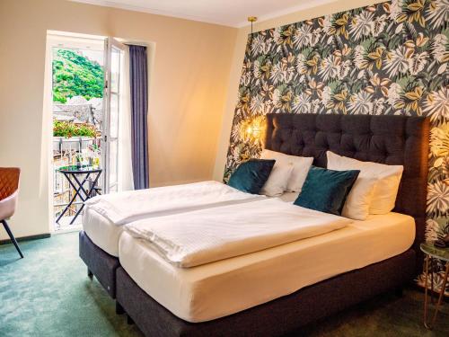 a bed with a white comforter and pillows in a room at Hotel Germania in Cochem