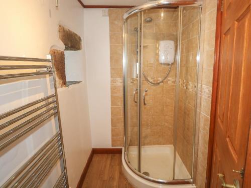 a shower with a glass door in a bathroom at The Hayloft in Liskeard