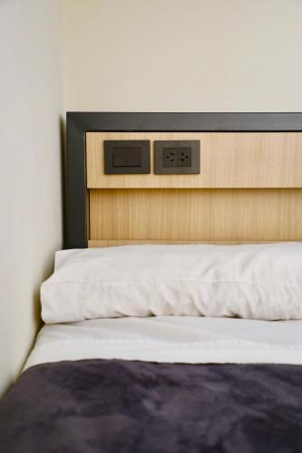 a bed with a clock on top of it at America Del Sur Hostel Buenos Aires in Buenos Aires