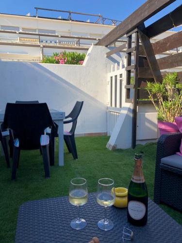 due bicchieri di vino seduti su un tavolo su un patio di Port nature 2 Villas studio a Cap d'Agde