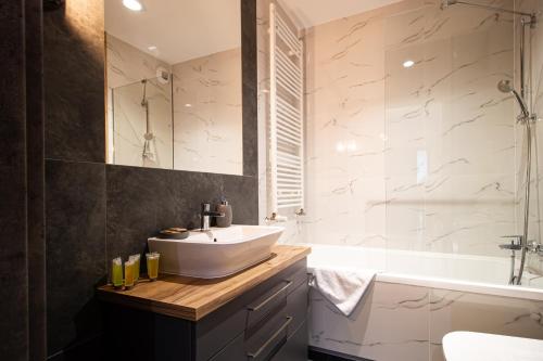 een badkamer met een wastafel en een bad bij Patio Praga Metro Apartment in Warschau