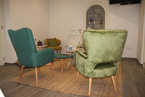 2 sillas verdes y una mesa en una habitación en Raiz Alentejana, en Reguengos de Monsaraz