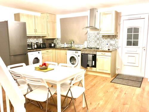a kitchen with a white table and white appliances at Grace Apartments - Living Stone 1 in Kent