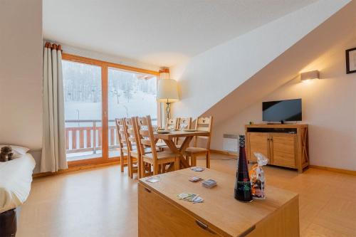 - un salon avec un lit et une table avec une télévision dans l'établissement Madame Vacances Résidence Le Parc Des Airelles, aux Orres