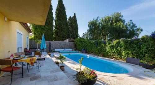 une cour avec une piscine, une table et des chaises dans l'établissement Villa de la Terre Blanche, à Sanary-sur-Mer