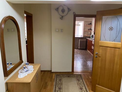 łazienka z umywalką, lustrem i drzwiami w obiekcie Apartament Aqua w mieście Călimăneşti