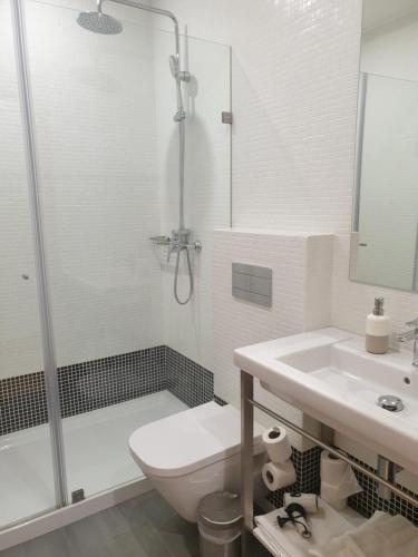 a bathroom with a shower and a toilet and a sink at Casa da Sé by PURUS in Coimbra